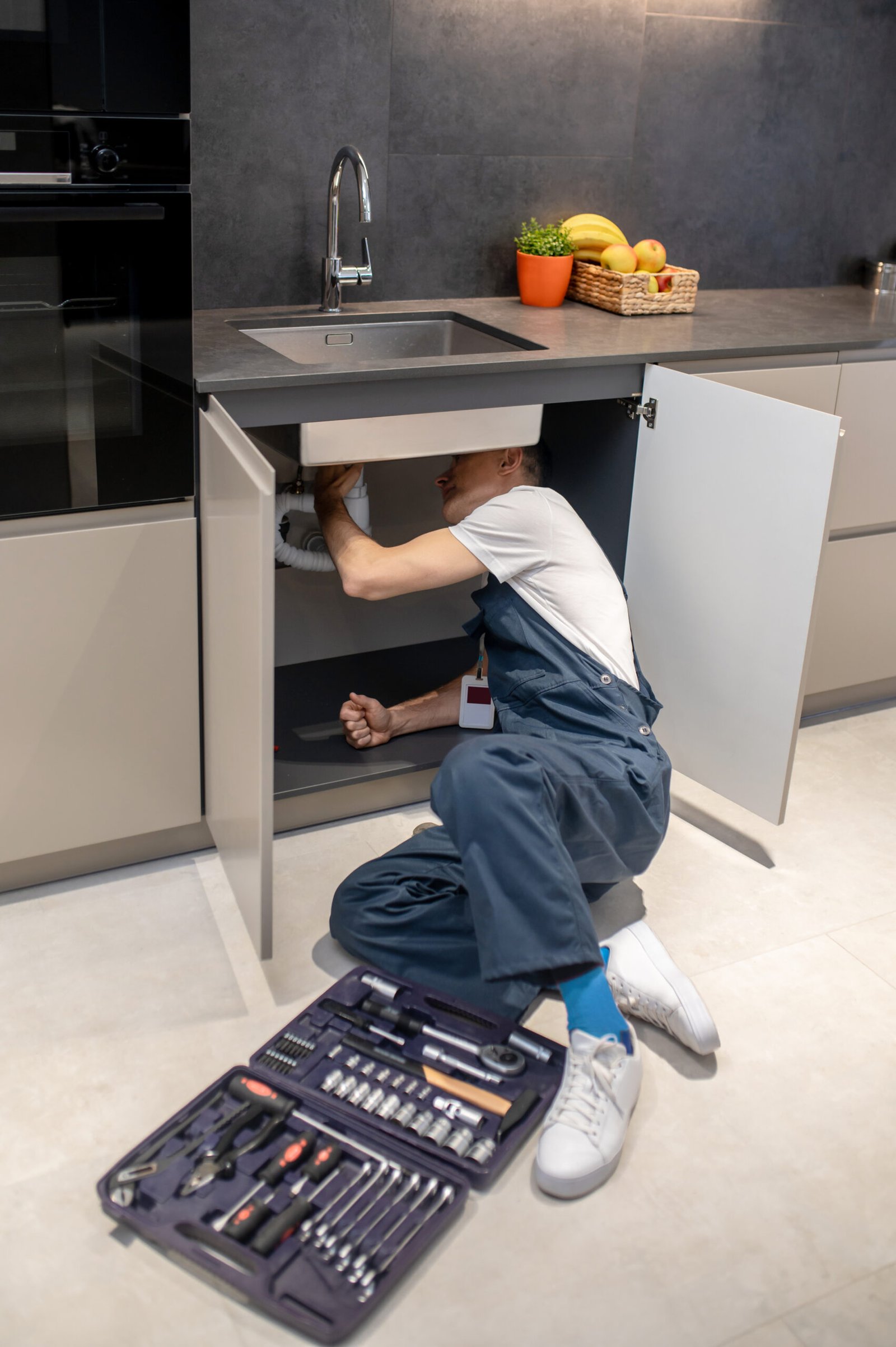 plumbing inspection man overalls with badge reclining floor with tools scaled 1